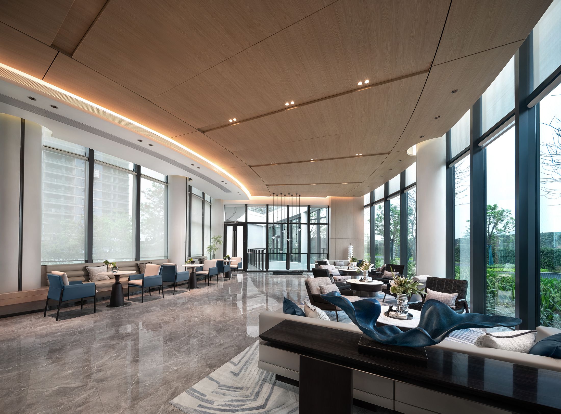 An inviting hotel lounge with warm wood, generous windows, and thoughtfully arranged seating